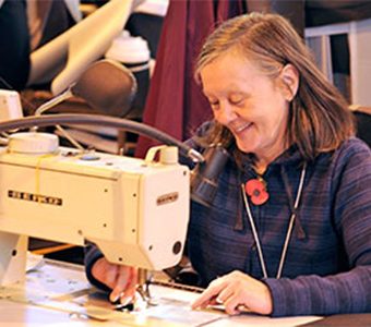 Smiling woman sewing with a sewing machine
